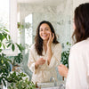 Applicazione crema viso PURA allo specchio in bagno